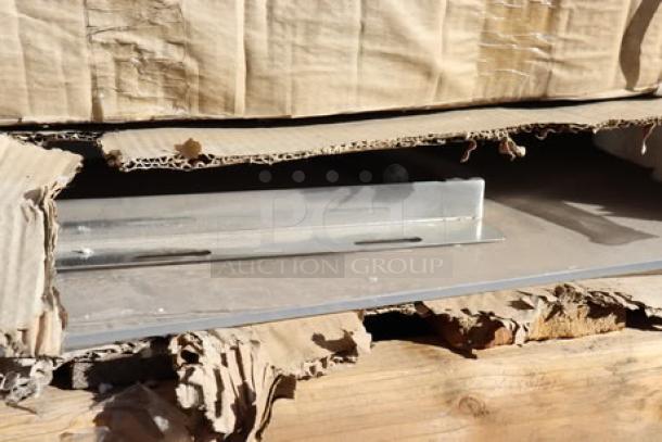 Massive mixed lot on pallets with items in damaged packaging, including new Regency grease trap, Lancaster table tops, and Bunn coffee grinder.