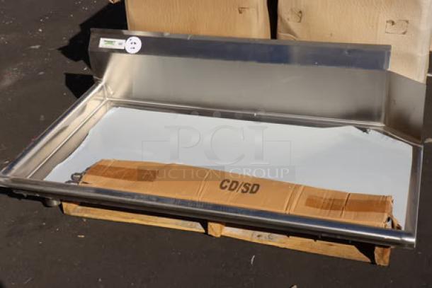 Stainless steel Regency CDT-48-L 4' clean dish table with left drainboard, out of packaging, resting on pallet.
