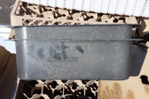 Plastic container on a pallet of glass racks. Some wear visible. Background shows rack detail with star-shaped slots.