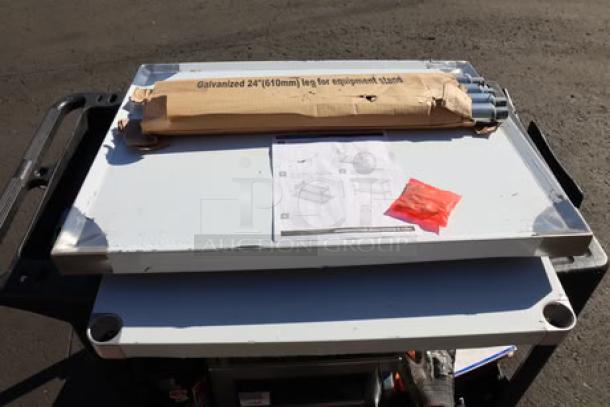 Galvanized 24" (610mm) leg for equipment stand in packaging on top of clean dish table with instructions and hardware.