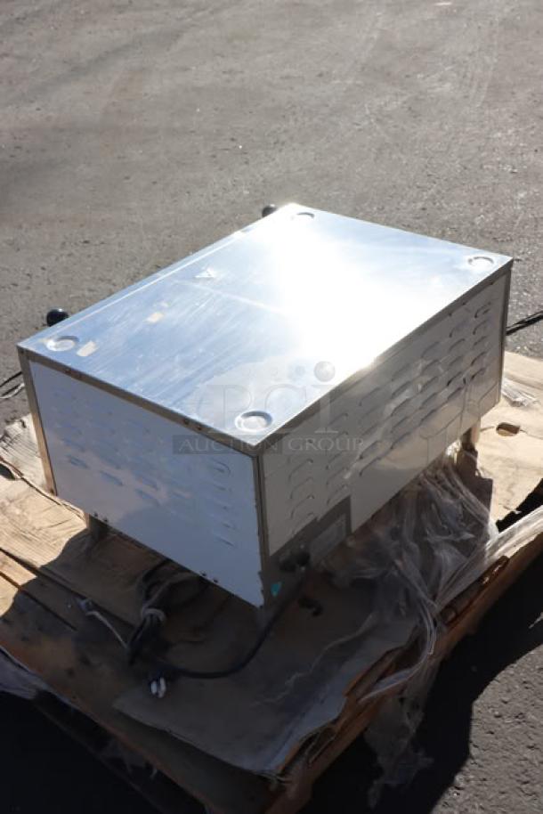 Mixed lot item on pallet featuring a reflective metal appliance, possibly part of auction description. Condition unknown.