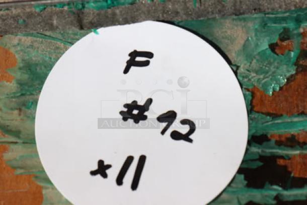 Stack of 11 wood table tops, top piece has cracks. Includes label marked "F #12 x11."
