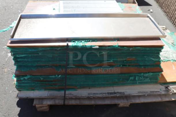 Stack of 11 wood tabletops on pallet, top piece cracked. 11 times your bid.