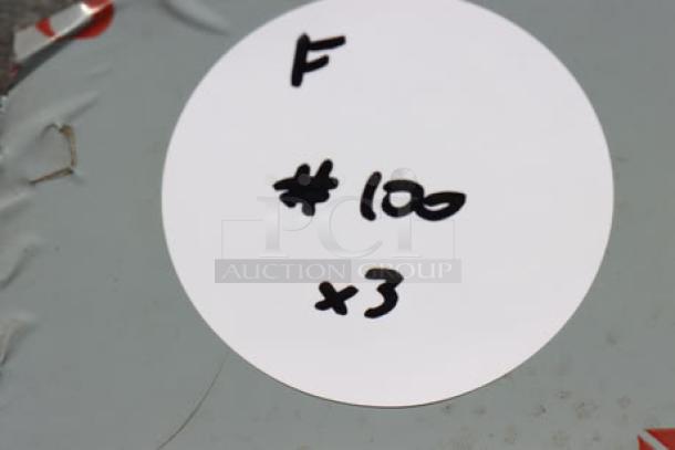 Round white label with handwritten markings: "F #100 x3" on gray surface. Labeling for auction item 3-piece lot.