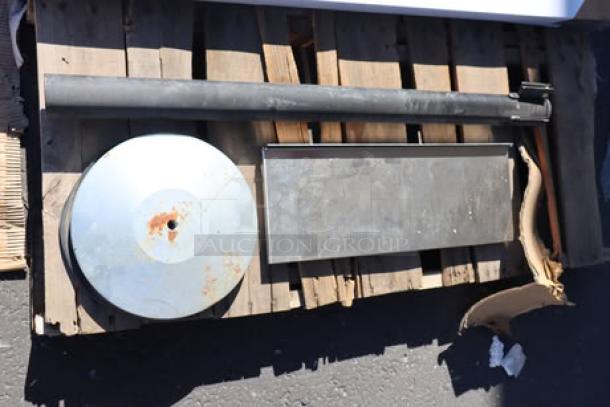 A weighted base and pole, possibly part of a stanchion, and a stainless steel overshelf; exhibit wear from storage.