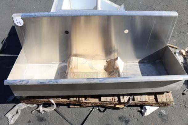 Brand new Regency 16-gauge stainless steel one-compartment corner mop sink, notched front, visible on pallet.