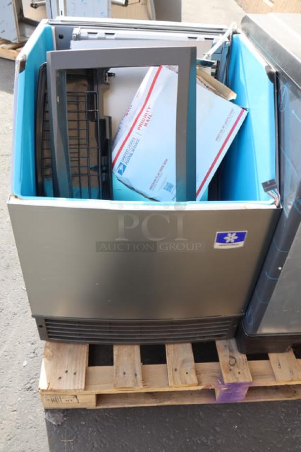 BRAND NEW SCRATCH-N-DENT Manitowoc UDF0240W ice machine on pallet. Includes bin and partial packaging; visible surface scratches.