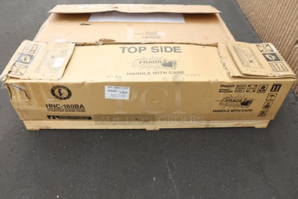 Hoshizaki HNC-180BA-L-SLH sushi display case in damaged box. Glass is broken; model and handling labels visible.