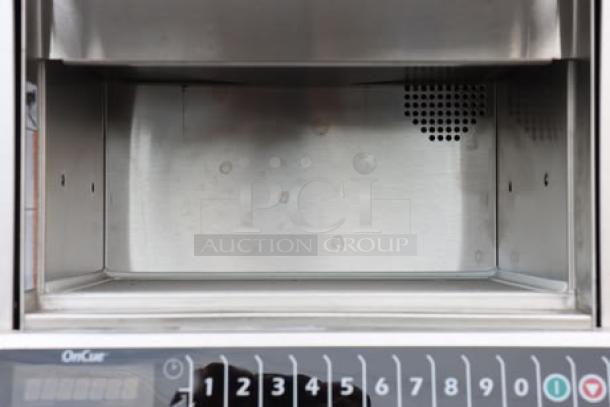 Brand new Amana AOC24 commercial microwave, 2400W, 208/240V. Visible control panel, slight scratches inside. S/N: 2506180055.