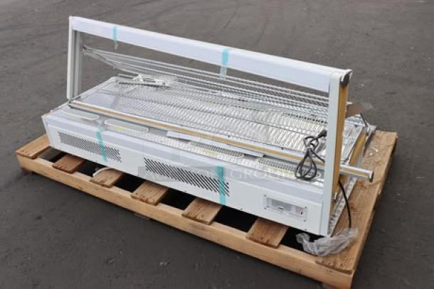 ChocoVision C116USREV2WHI Revolation 2 Chocolate Tempering Machine and heated display on a pallet, condition unclear.