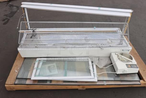 ChocoVision C116USREV2WHI chocolate tempering machine and heated display, for parts, on pallet. 110V, 60Hz, 1.5 lb capacity.