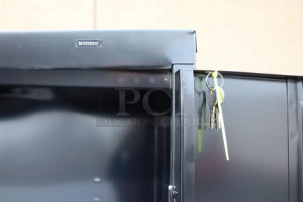 Tennsco black storage cabinet, model 6618DH-BLK, with solid doors, features keys hanging on a clip.