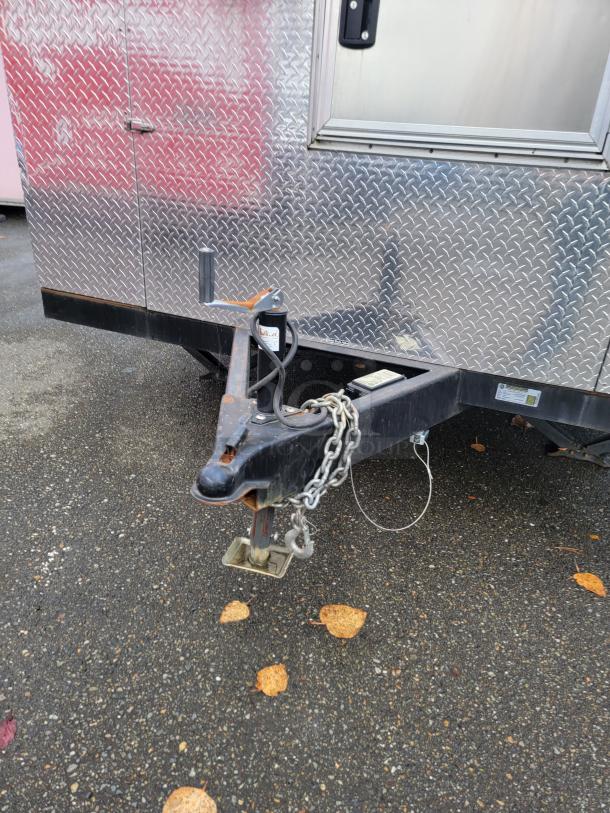 2021 16' mobile kitchen trailer with diamond-plate exterior, robust hitch, and secure lock mechanism.