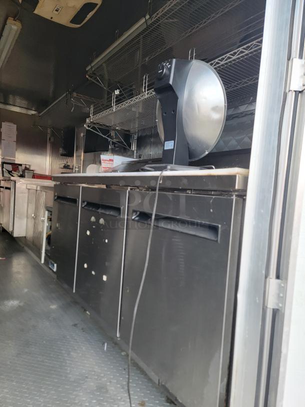 2021 Quality 16' mobile kitchen trailer interior, featuring Arctic Air refrigeration units, metal shelving, and diamond-plate flooring.