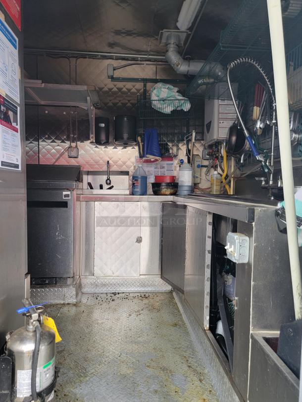 2021 16' REEF/NBRHD mobile kitchen trailer interior showing triple sink, Arctic Air units, and diamond-plate flooring.