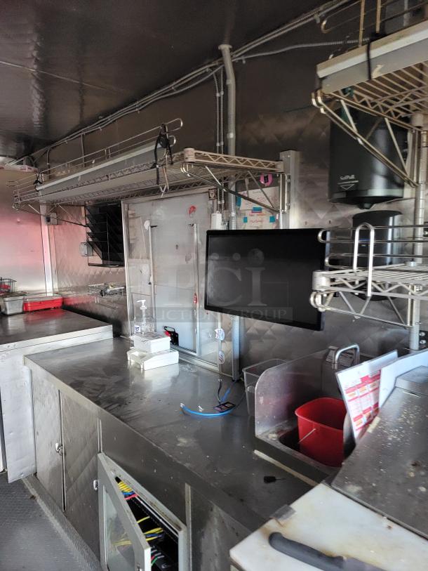 2021 16' Reef/NBRHD mobile kitchen trailer interior with Arctic Air refrigeration, stainless steel counters, and storage shelves.