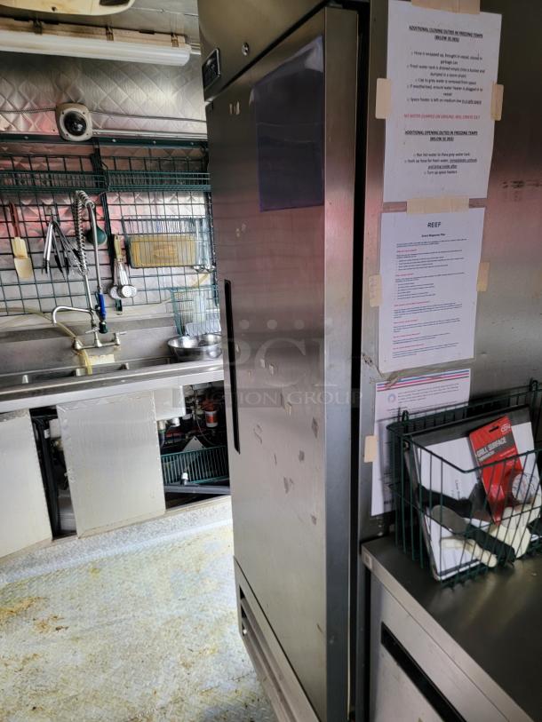 2021 Quality 16' mobile kitchen trailer interior with Arctic Air fridge, triple sink, hand-washing station, and security camera.