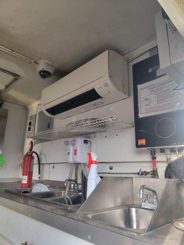 2019 Diamond Cargo 16' food trailer interior with stainless steel sinks, Mitsubishi HVAC, and fire extinguisher in view.