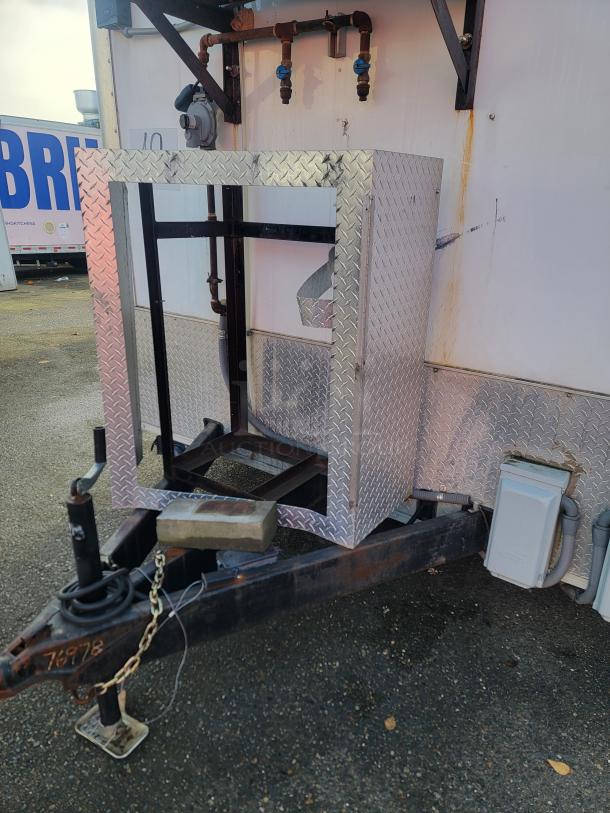 2019 Diamond Cargo 16' food trailer hitch area with metal diamond plate cover and attached utility connections.