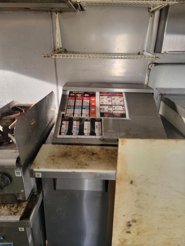 Interior of 2019 Diamond Cargo 16' Ghost Kitchen Food Trailer with stainless steel surfaces, menu system, and cooking equipment.