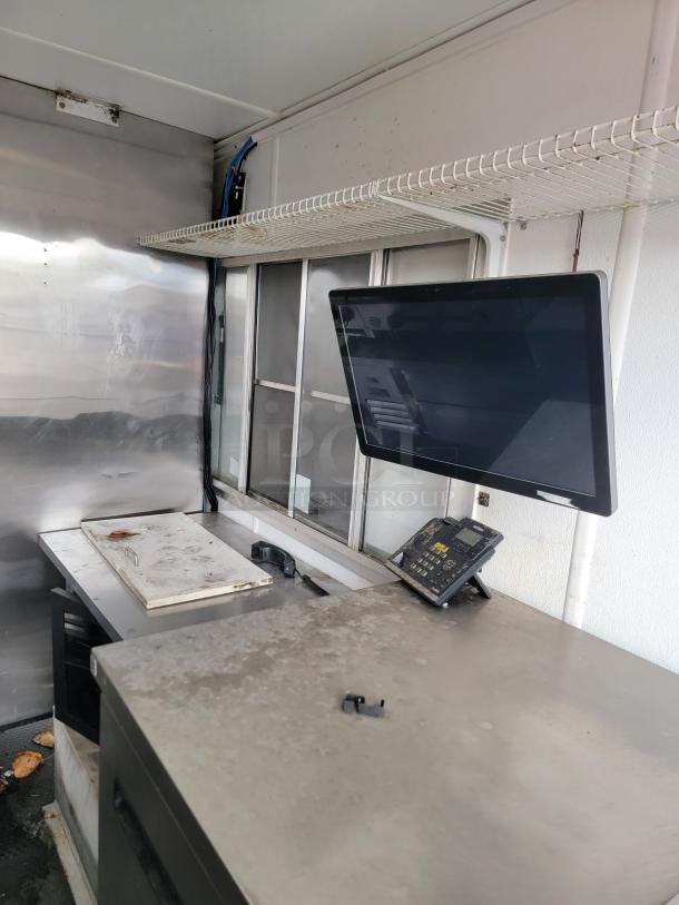 2019 Diamond Cargo 16' food trailer interior, featuring a stainless steel prep area, display monitor, and equipment phone. Dust visible.