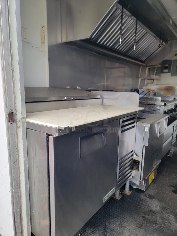 2019 Diamond Cargo 16' food trailer interior with commercial exhaust hood, stainless steel True refrigeration, and cooking equipment.