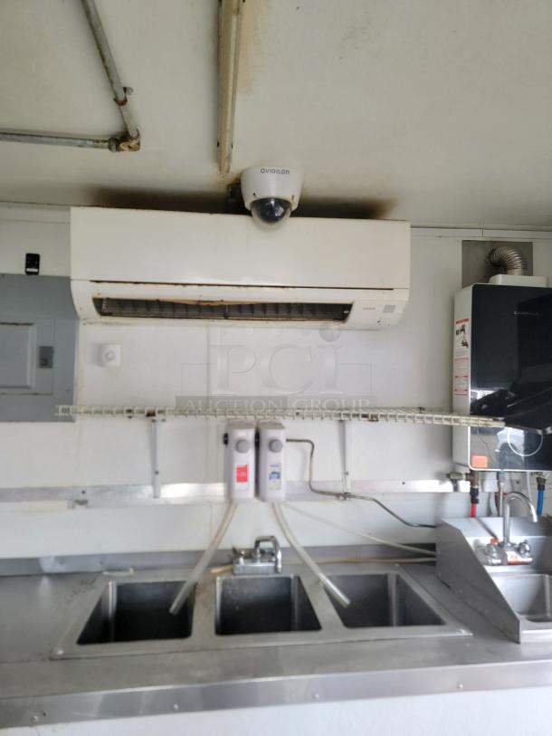 2019 Diamond Cargo food trailer interior showing Mitsubishi Mini-Split HVAC, multi-basin sink, and security camera.