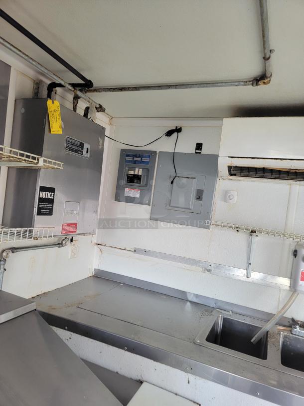 2019 Diamond Cargo food trailer interior showing electrical panel, ANSUL system, and sink area. Clean and ready for use.