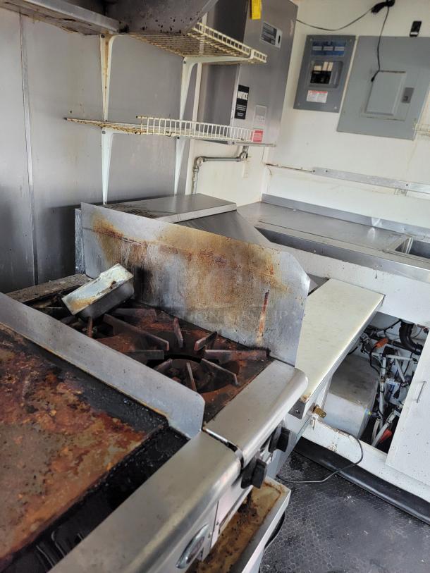 2019 Diamond Cargo 16' food trailer interior with Pitco fryer, Wells griddle, and commercial exhaust hood. Visible wear on surfaces.