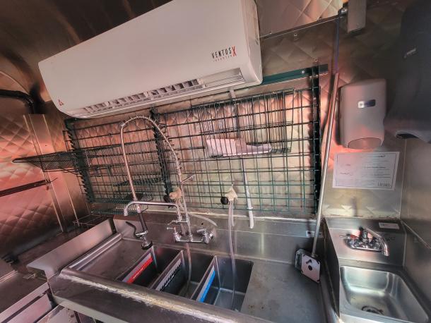 Stainless steel sink setup in a 2020 Diamond Cargo 16' food trailer. Equipped for gas cooking and refrigeration. VentusX inverter visible.