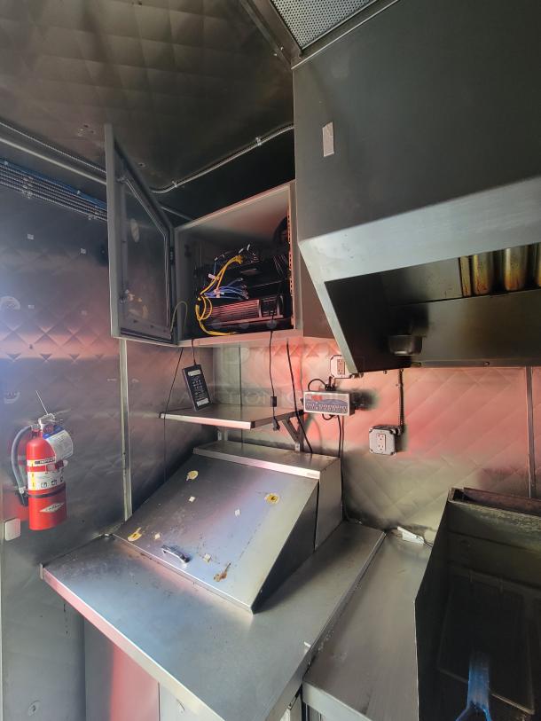 2020 Diamond Cargo 16' food trailer interior, featuring commercial appliances, robust electrical system, and storage compartment.