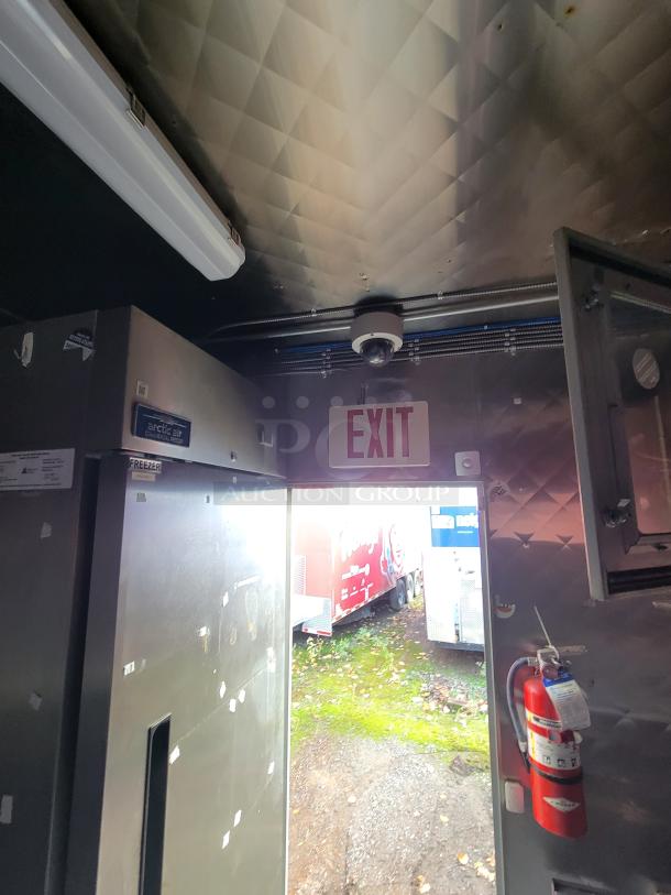 Interior view of a 2020 Diamond Cargo 16' food trailer. Features commercial appliances, EXIT sign, and fire extinguisher.