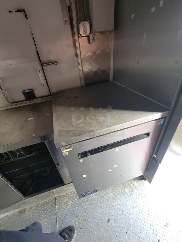 2020 Diamond Cargo 16' food trailer interior with stainless steel surfaces, robust electrical system, and commercial refrigerator.