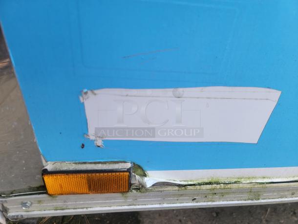 Close-up of a section of the 2019 Quality 24' food trailer exterior showing minor wear and a reflective marker.