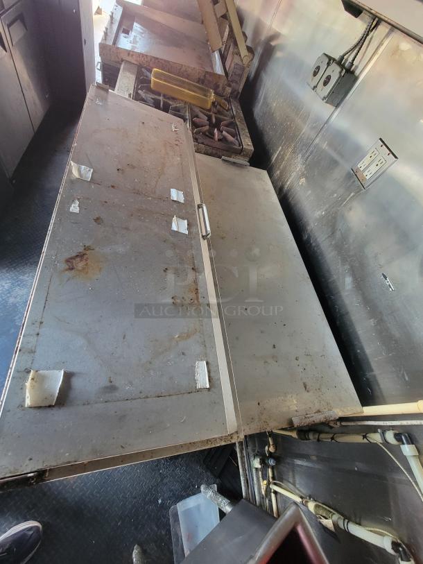 2019 Quality 24' food trailer interior showing prep area and stovetop, equipped for commercial use, moderate wear.