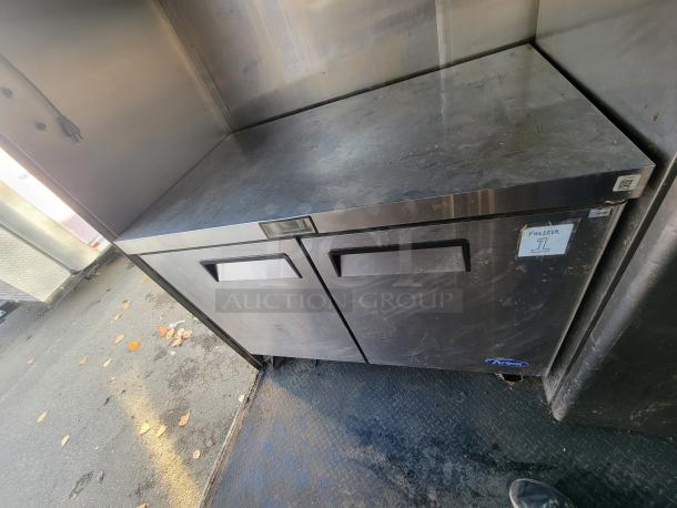 Stainless steel Asber under-counter freezer in a 2019 Quality 24' food trailer, labeled "Freezer 1."