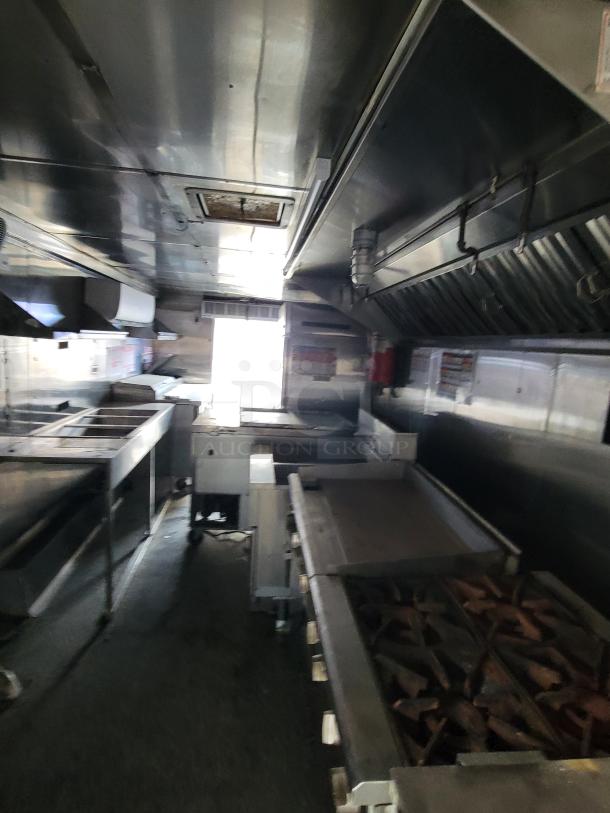2019 24' Quality food trailer interior with stainless steel kitchen, Royal griddle/range, Pitco fryer, and refrigeration units.
