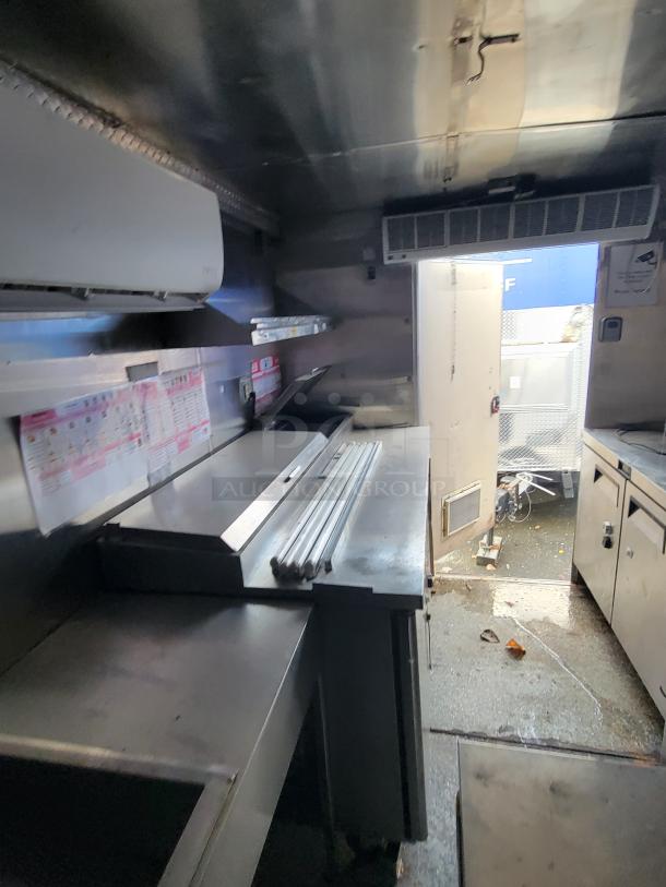 2019 Quality 24' food trailer interior with stainless steel kitchen, pizza prep table, and equipment. Fully equipped, turnkey.