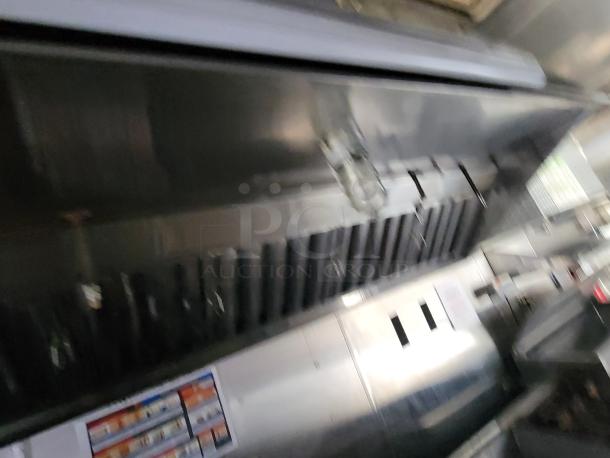 2019 24' Quality commercial food trailer interior, showing stainless steel kitchen with exhaust hood and appliance units.