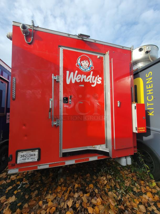 Red 2021 Wendy's ghost kitchen trailer, fully equipped, triple axle, custom-built for efficiency, features commercial appliances.