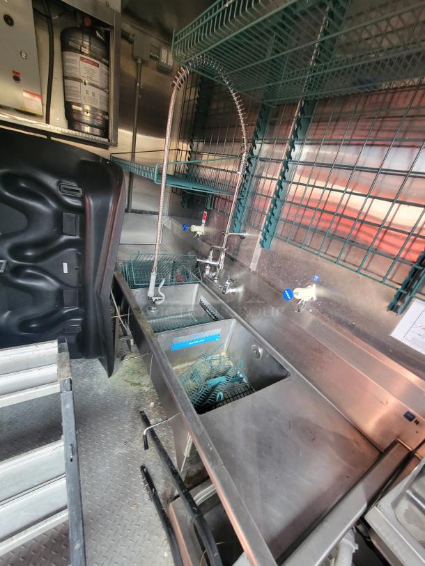 2021 Wendy's Mobile Ghost Kitchen trailer interior showing stainless steel sinks and countertops, with industrial faucets and racks.
