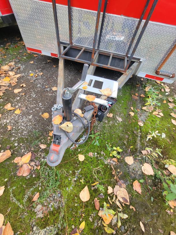 2021 28' Wendy's Mobile Ghost Kitchen trailer hitch, part of a high-end commercial kitchen setup, on mossy ground with fallen leaves.
