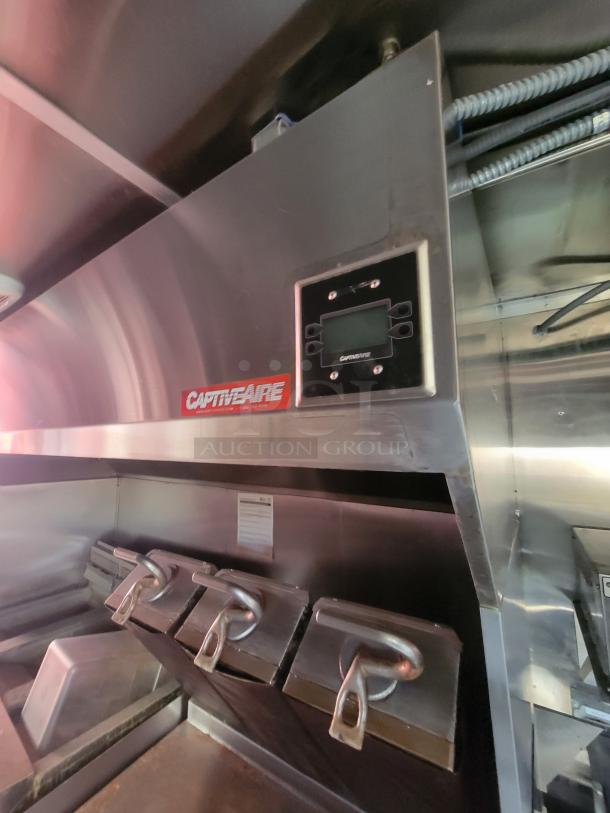 Stainless steel CaptiveAire kitchen ventilation system in a 2021 high-end mobile ghost kitchen trailer, featuring commercial appliances.