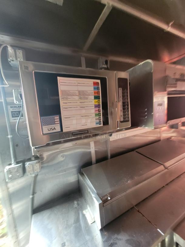 Interior of a 2021 Titanium Cargo Trailer ghost kitchen, featuring commercial-grade appliances and stainless steel workspace.