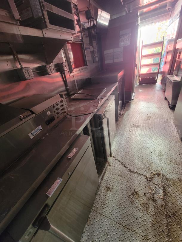 2021 28' Wendy's mobile ghost kitchen interior, featuring stainless steel commercial appliances and diamond plate flooring.
