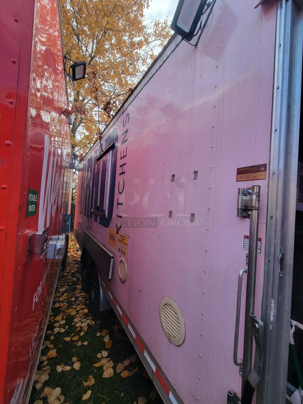 2021 Quality Kitchens 24' mobile food trailer, pink exterior, dual-axle, designed for ghost kitchen use, visible side markings.