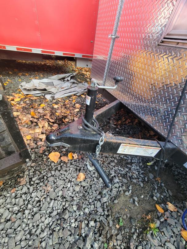 2021 Quality Kitchens 24' mobile food trailer hitch detail; red exterior, diamond plate finish, robust construction.