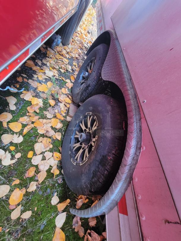 2021 Quality Kitchens 24' mobile food trailer, showing dual-axle wheels on autumn leaves, red exterior.