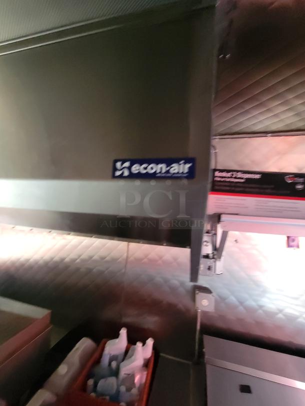 2021 Quality Kitchens 24' mobile food trailer interior view with Econ-Air exhaust hood and stainless steel walls.