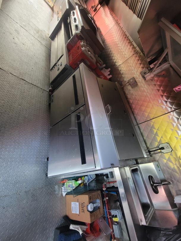 2021 Quality Kitchens 24' mobile food trailer interior, featuring stainless steel counters, Arctic Air refrigeration, and Econ-Air exhaust hood.